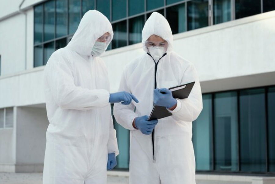 Staff wearing white non-woven protective clothing record form data