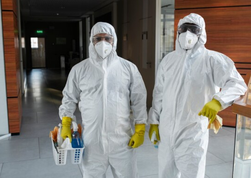 Staff wearing protective clothing doing cleaning work